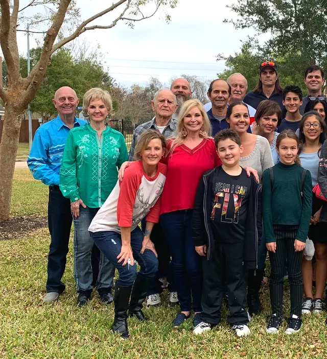 A large group of families gathered outdoors for a photo